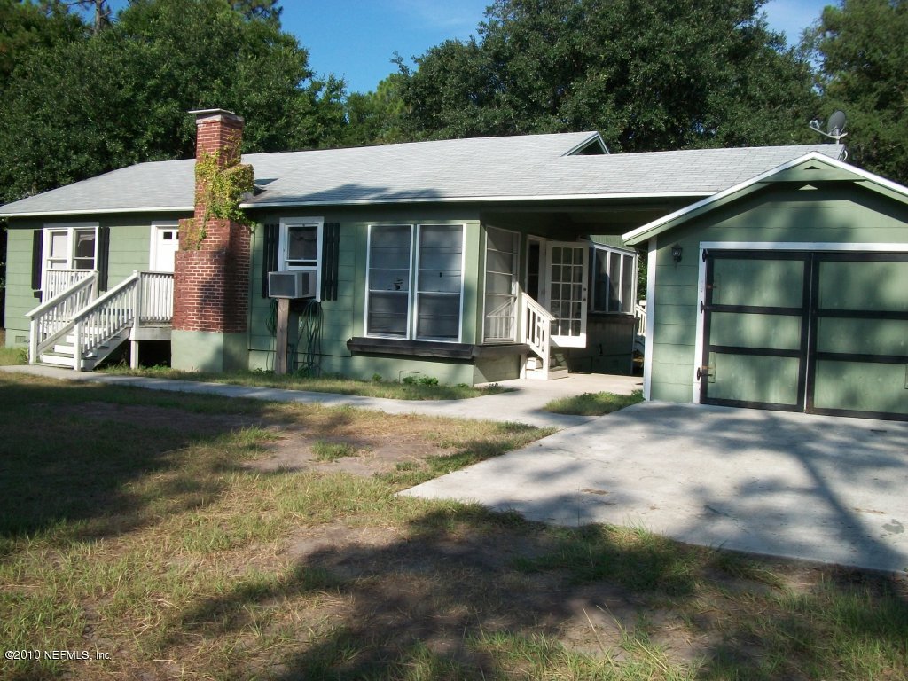 96519 Chester Road Yulee, FL 32097 - Photo 1 of 5 a front view of a house with a yard