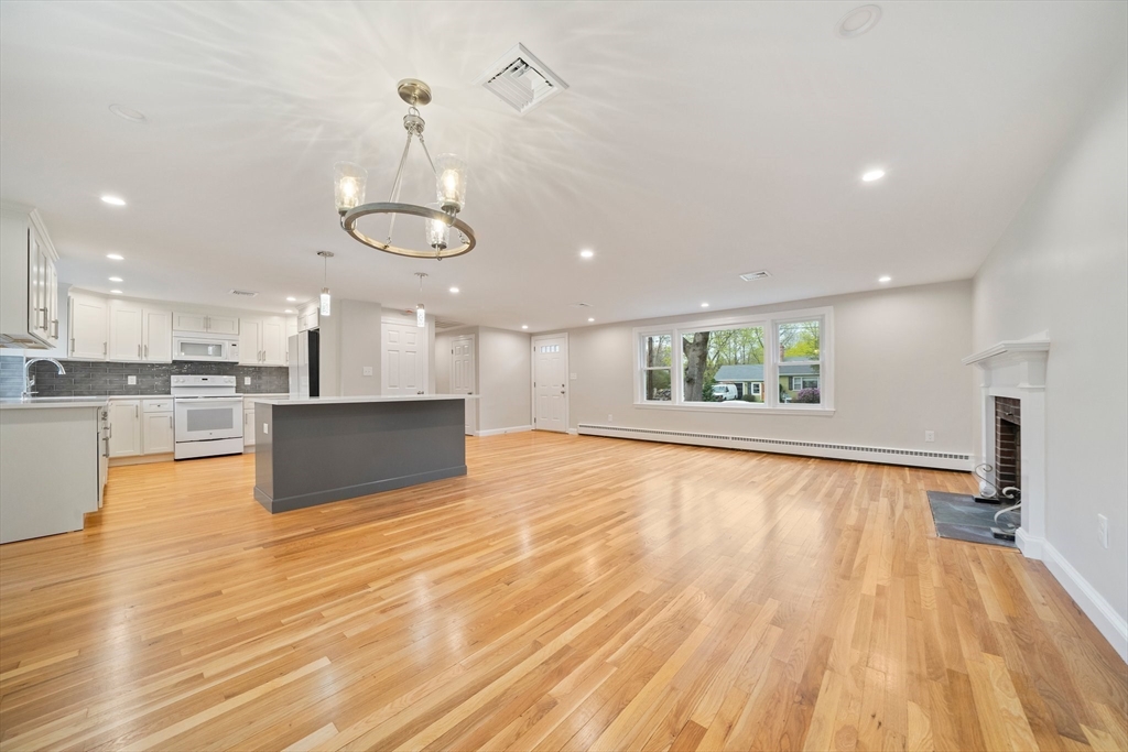 26 Leonard Road Sharon, MA 02067 - Photo 1 of 25 a view of an empty room and kitchen with wooden floor and window