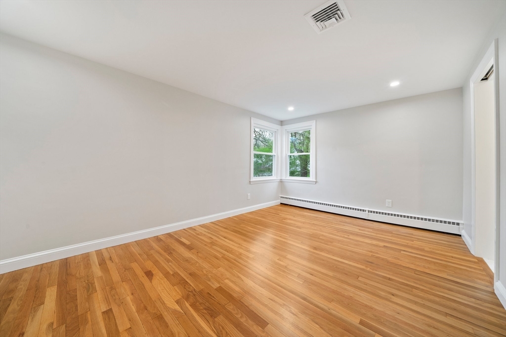 26 Leonard Road Sharon, MA 02067 - Photo 13 of 25 a view of an empty room with wooden floor and a window