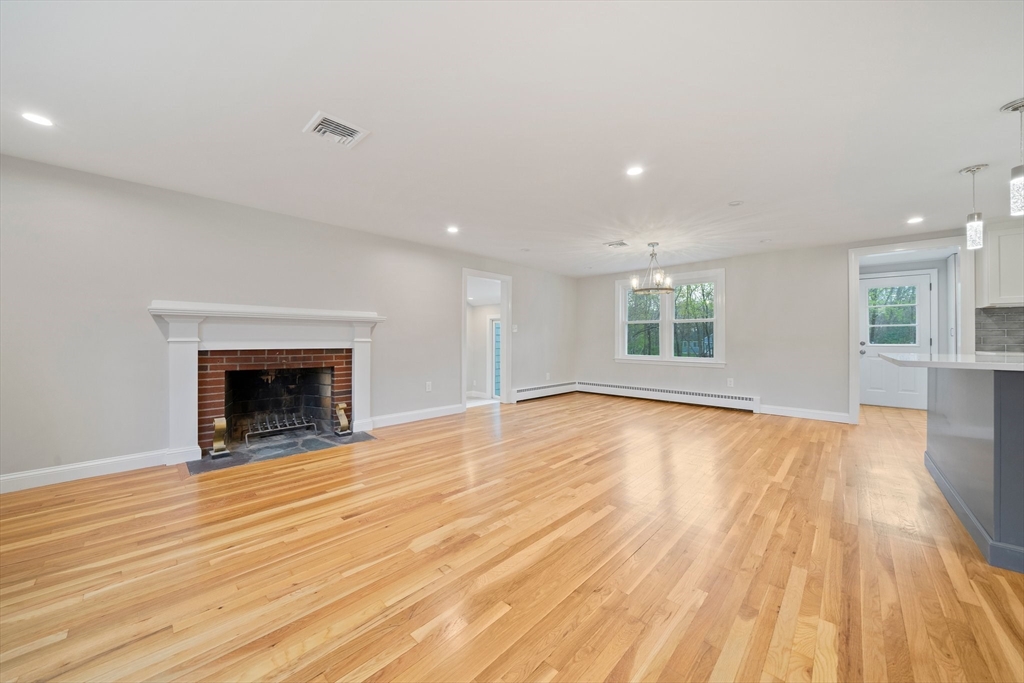 26 Leonard Road Sharon, MA 02067 - Photo 4 of 25 a view of an empty room with wooden floor fireplace and a window