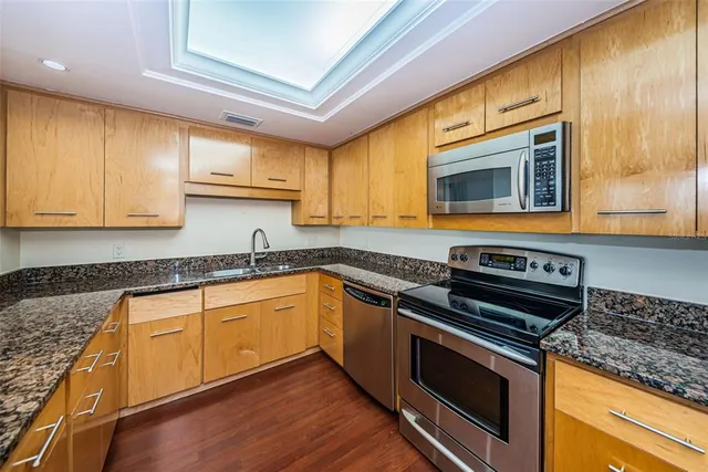 a kitchen with granite countertop a refrigerator and a sink