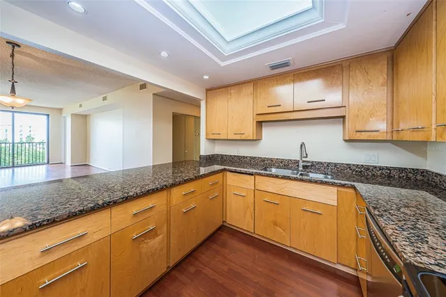 a kitchen with granite countertop stainless steel appliances and refrigerator