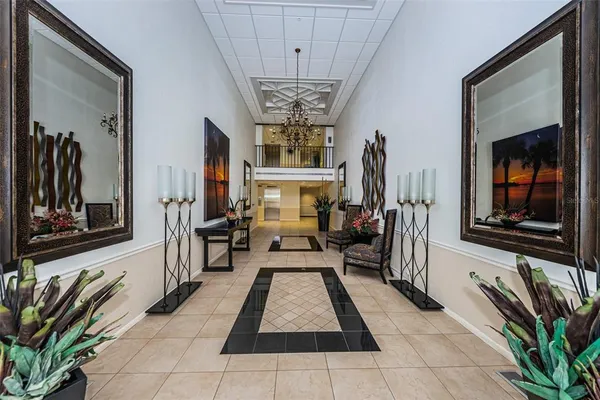 a living room with furniture a chandelier and a flat screen tv