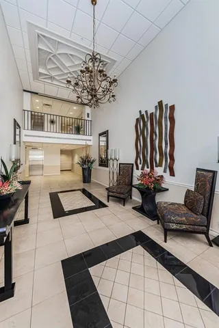 a living room with furniture a chandelier and a flat screen tv