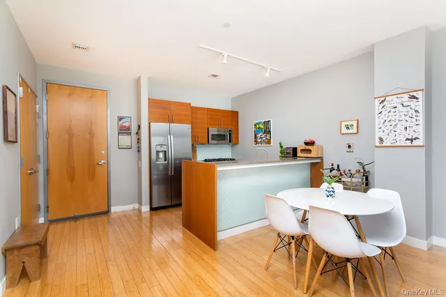 a view of kitchen with refrigerator and wooden floor