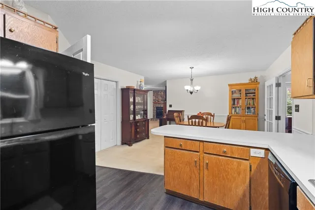 a kitchen with kitchen island a counter top space a sink a refrigerator and a stove