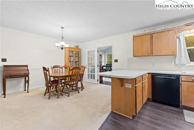 a kitchen with stainless steel appliances kitchen island granite countertop a table chairs sink and cabinets