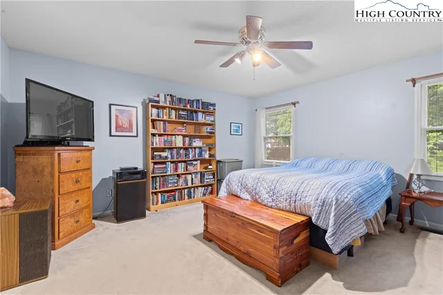 a bedroom with a bed furniture and flat screen tv