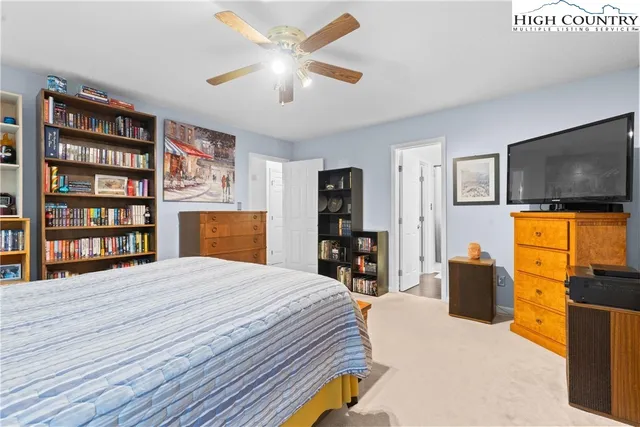 a bedroom with a bed a dresser and a flat screen tv