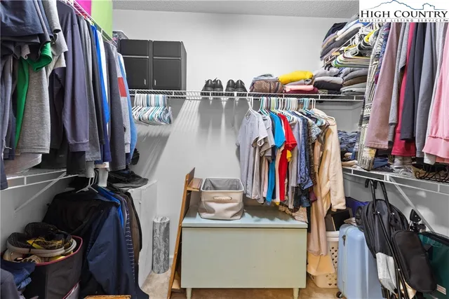 a view of walk in closet with clothes and shoes