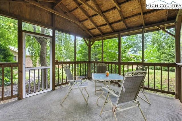 a view of a patio with a table chairs and a small yard