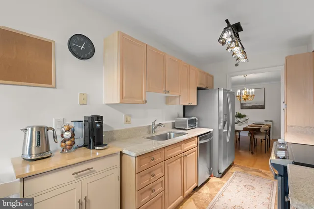 a kitchen view with stainless steel appliances a stove cabinets and a window