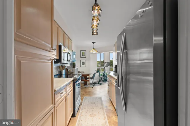 a dining room filled chandelier and kitchen view