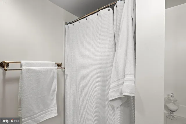 a bath tub sitting next to a white toilet and a shower