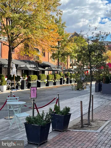 a view of patio with chairs and tables under an umbrella