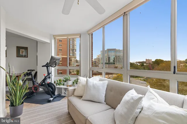 a living room with furniture tv and a floor to ceiling window
