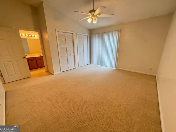 a big room with closet and ceiling fan