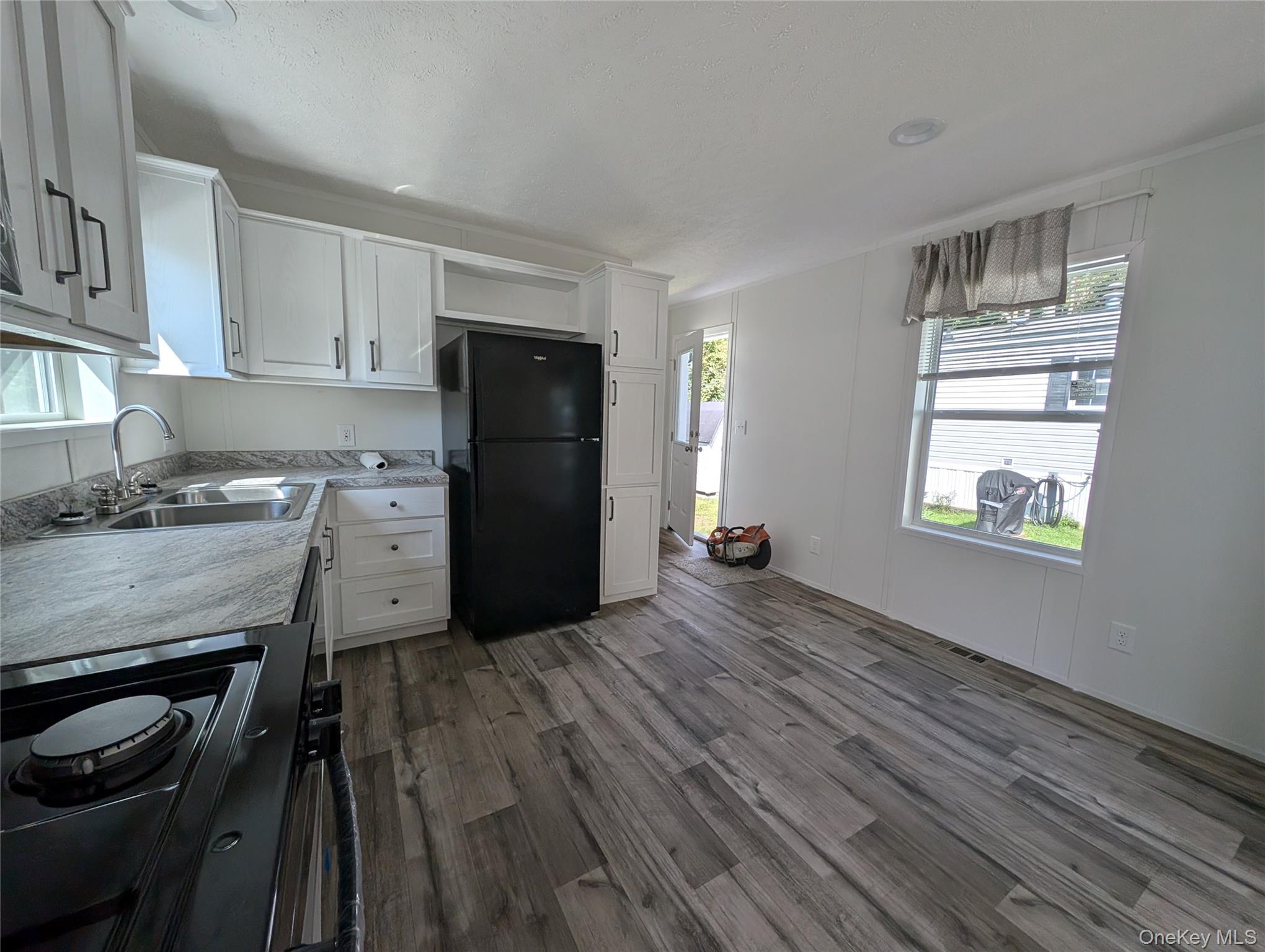 11 Square Hill Road, Unit 27 New Windsor, NY 12553 - Photo 5 of 14 Kitchen with white cabinetry, a sink, black appliances, and dark wood-type flooring