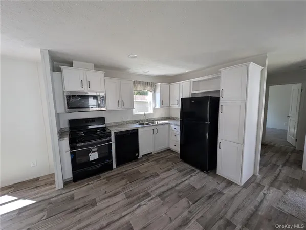 a kitchen with granite countertop a refrigerator and a stove top oven