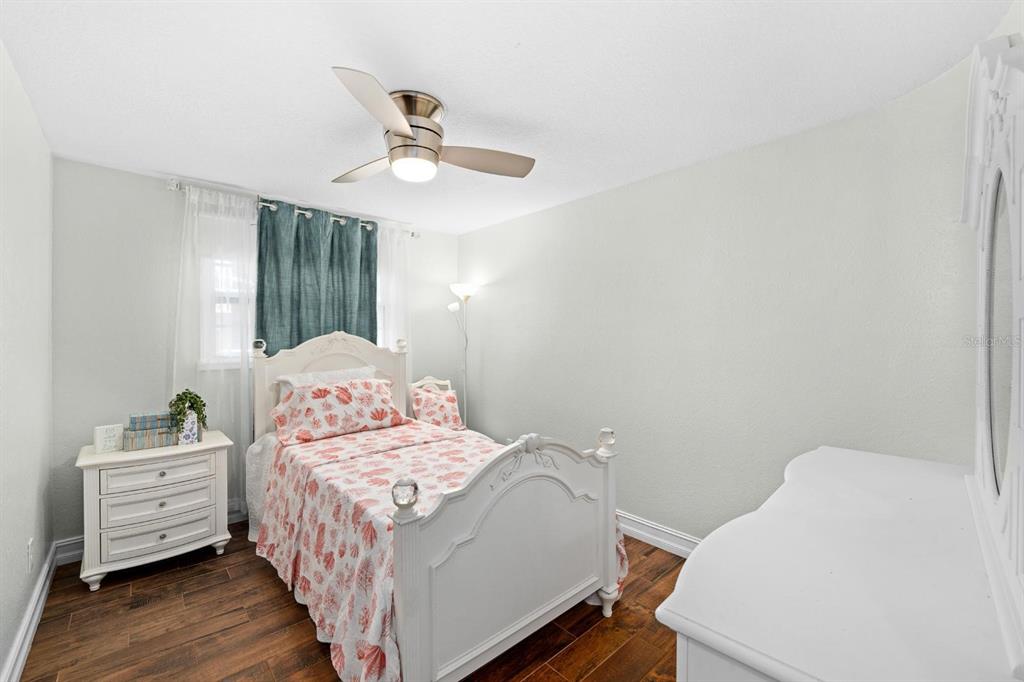 8644 May Circle Tampa, FL 33614 - Photo 11 of 28 a bedroom with a bed and wooden floor
