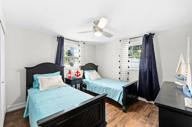 a bedroom with two beds and a flat tv screen on a dresser