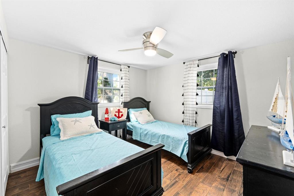 8644 May Circle Tampa, FL 33614 - Photo 13 of 28 a bedroom with two beds and a flat tv screen on a dresser