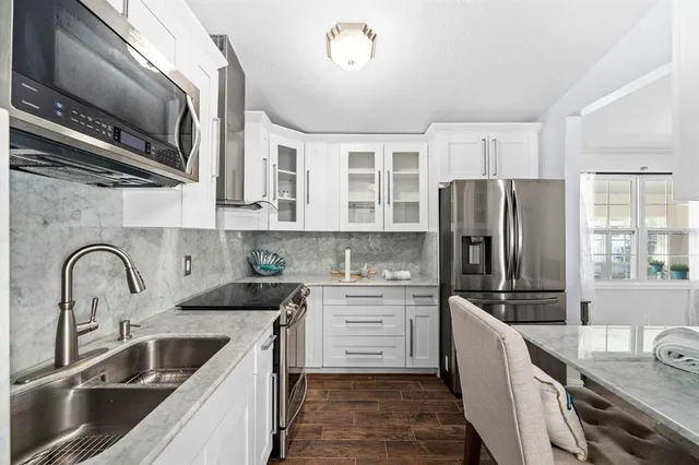 a kitchen with a refrigerator sink and wooden cabinets