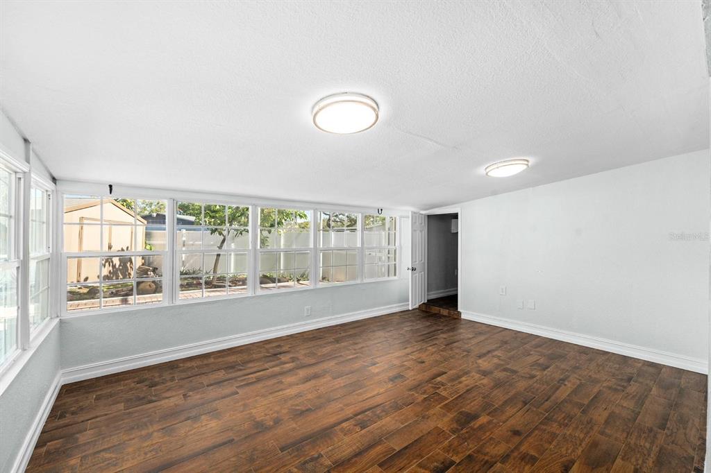 8644 May Circle Tampa, FL 33614 - Photo 9 of 28 an empty room with wooden floor and windows