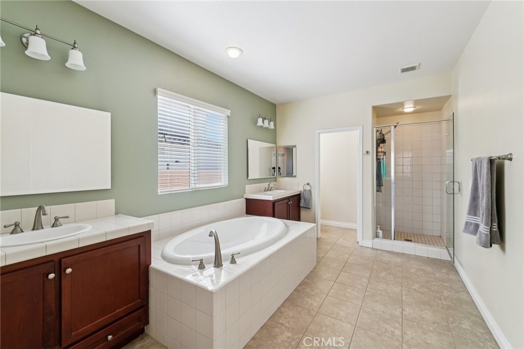 28552 Rustic Glen Street Menifee, CA 92584 - Photo 21 of 48 Well-appointed primary bathroom with dual sinks and relaxing soaking tub