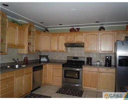 147 Redpine Loop Old Bridge, NJ 08857 - Photo 3 of 25 a kitchen with granite countertop a sink stainless steel appliances and cabinets