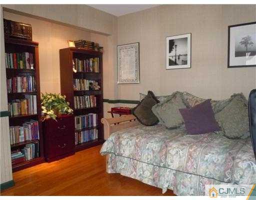 147 Redpine Loop Old Bridge, NJ 08857 - Photo 9 of 25 a large bed sitting in a bedroom next to a book shelf