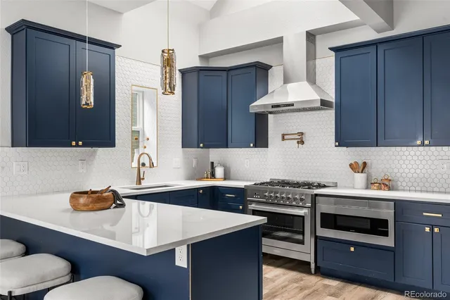 a kitchen with stainless steel appliances granite countertop a sink stove and cabinets