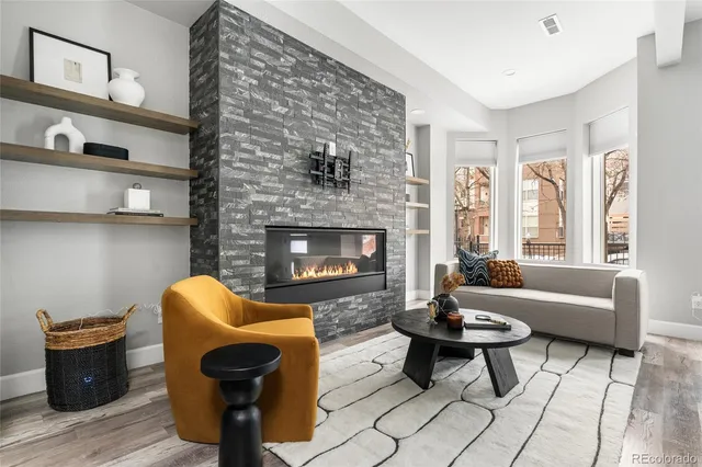 a living room with furniture a large window and a chandelier