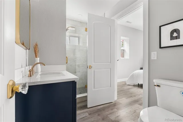 a bathroom with a granite countertop sink toilet and mirror