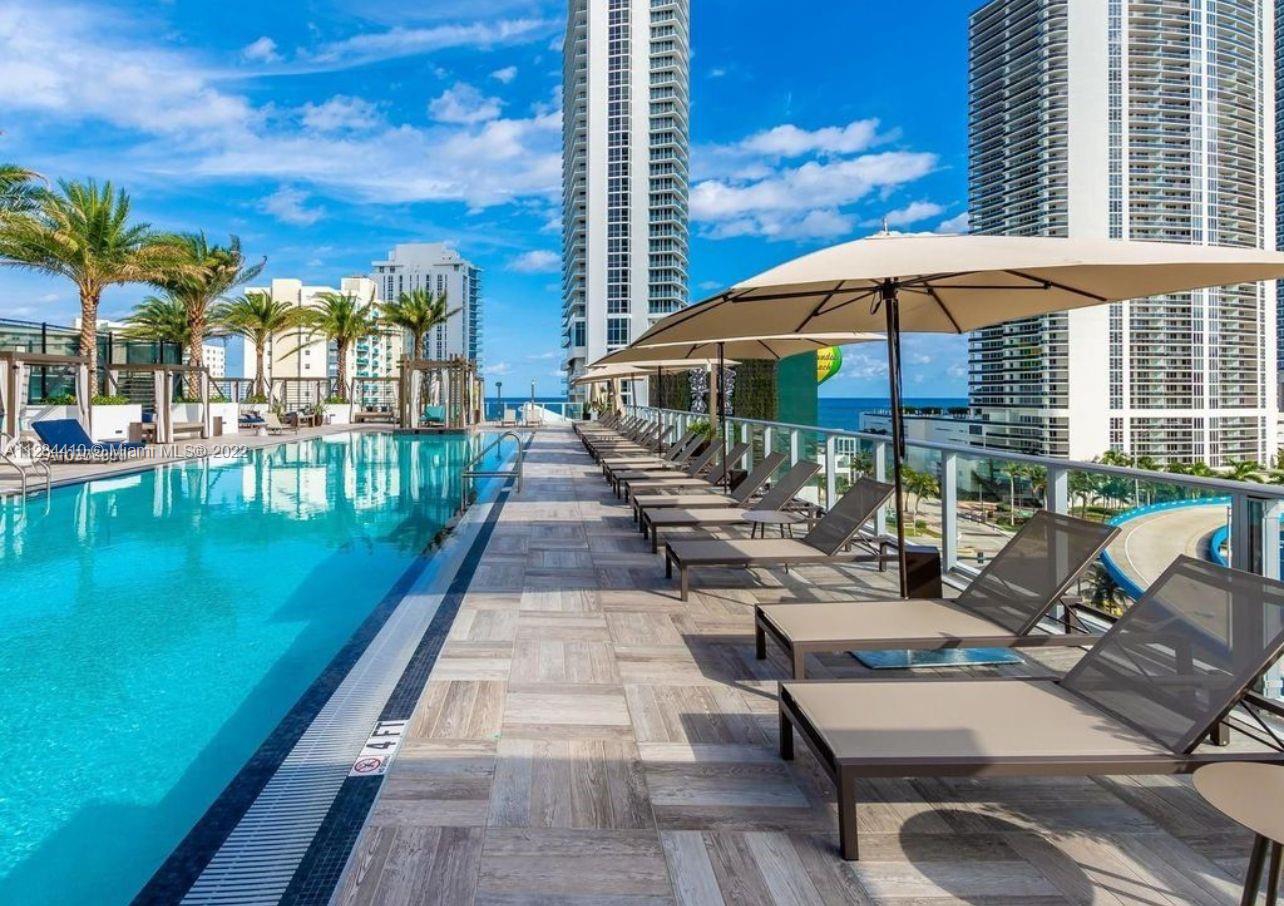 4010 South Ocean Drive, Unit R3106 Hollywood, FL 33019 - Photo 16 of 19 a view of a swimming pool with lounge chairs in patio