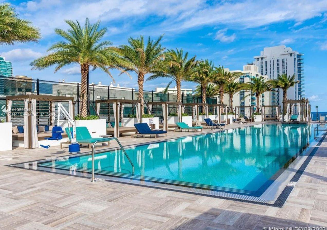 4010 South Ocean Drive, Unit R3106 Hollywood, FL 33019 - Photo 18 of 19 a view of a swimming pool with a patio and a garden