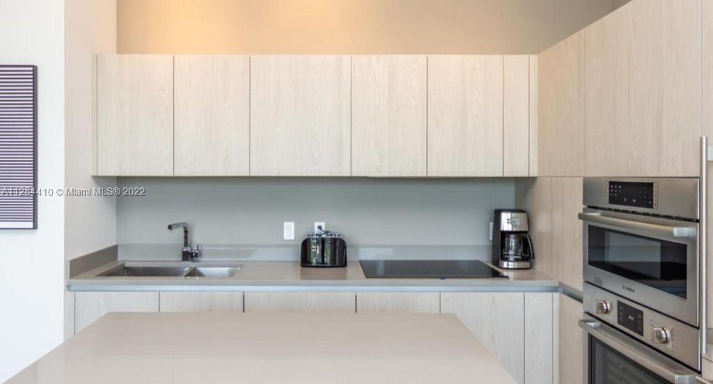 4010 South Ocean Drive, Unit R3106 Hollywood, FL 33019 - Photo 6 of 19 a kitchen with stainless steel appliances granite countertop a sink a microwave and cabinets