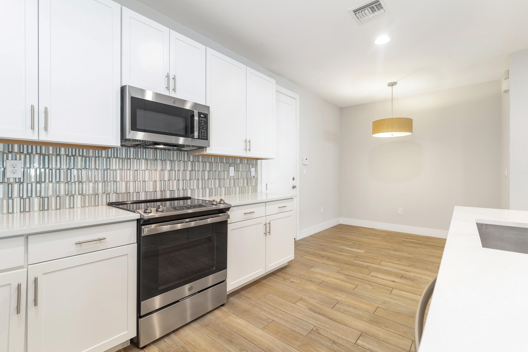 3764 Lambert Avenue West Palm Beach, FL 33405 - Photo 11 of 25 a kitchen with granite countertop cabinets stainless steel appliances and wooden floor