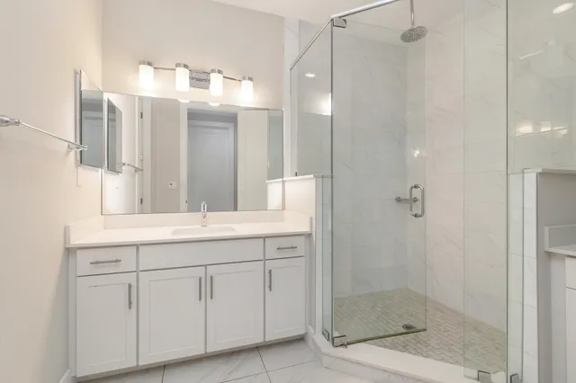 a bathroom with a shower sink and mirror