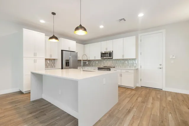 a kitchen with kitchen island a sink stainless steel appliances and cabinets