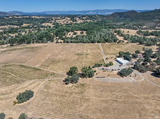 an aerial view of house with yard and mountain view in back