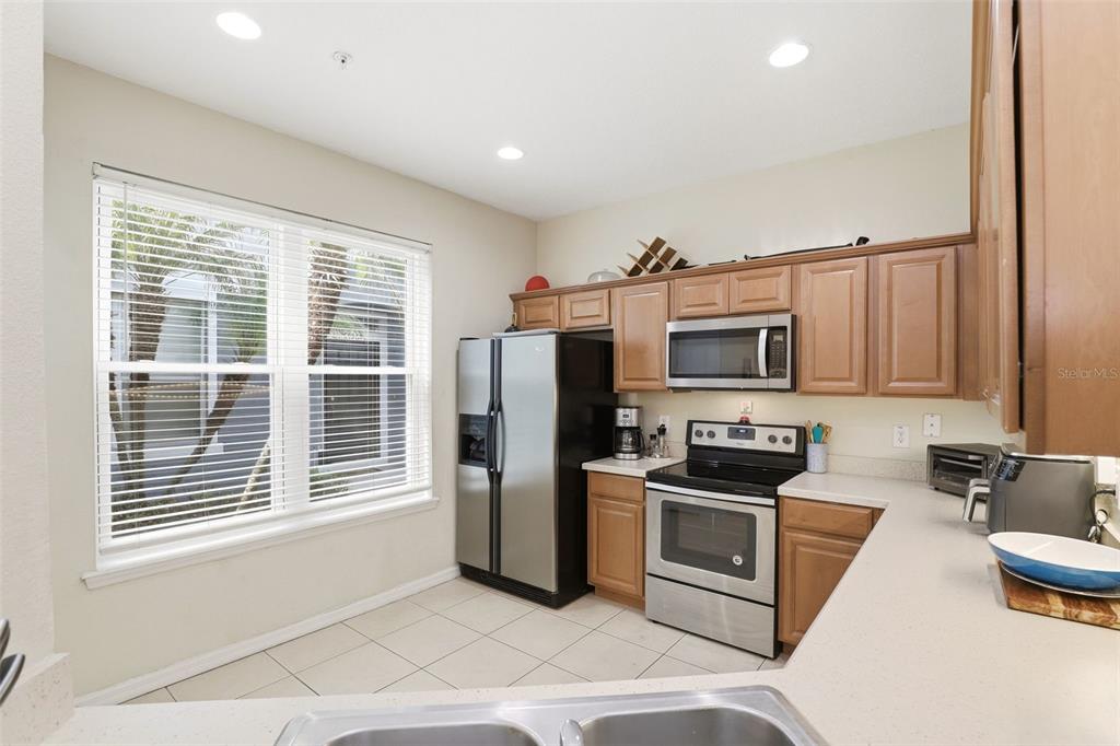 6458 South Goldenrod Road, Unit 29B Orlando, FL 32822 - Photo 13 of 40 a kitchen with stainless steel appliances a refrigerator a stove a sink and a granite counter tops