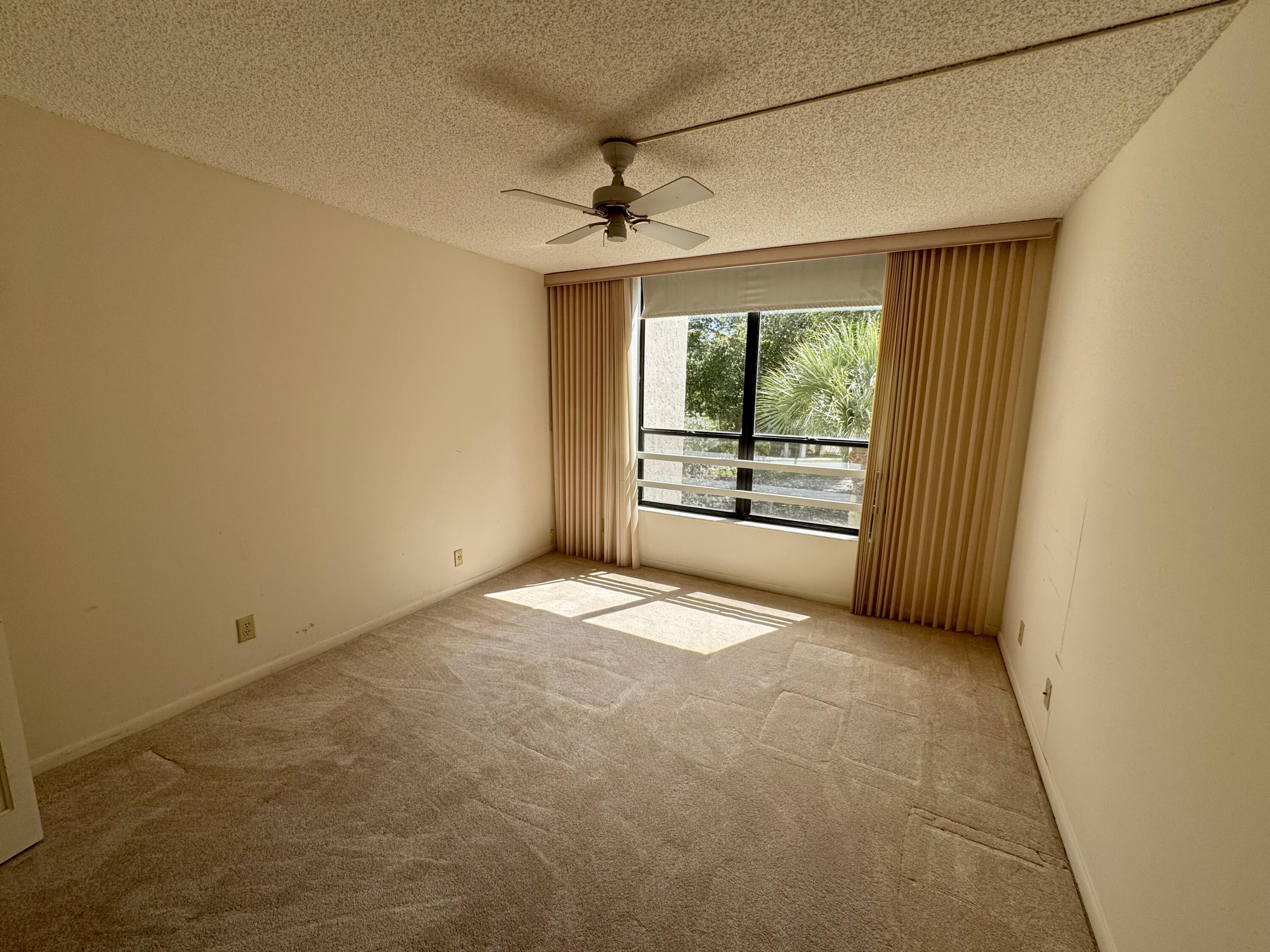 8050 West McNab Road, Unit 320 Tamarac, FL 33321 - Photo 17 of 24 an empty room with windows curtains and outdoor view