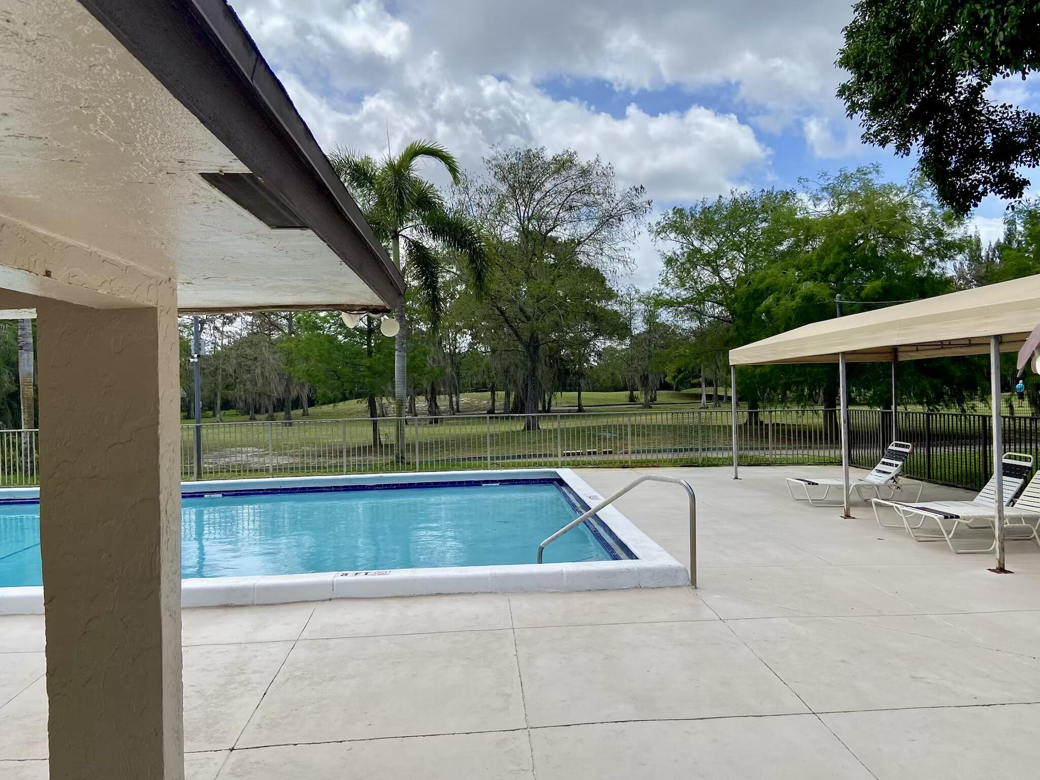 8050 West McNab Road, Unit 320 Tamarac, FL 33321 - Photo 23 of 24 a view of a swimming pool with a lounge chair