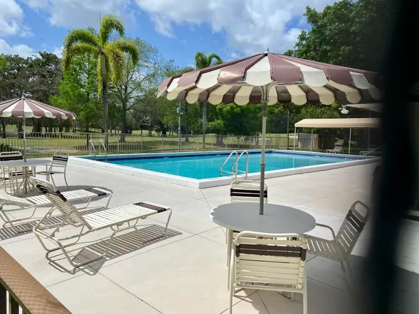 a view of a backyard with swimming pool and furniture