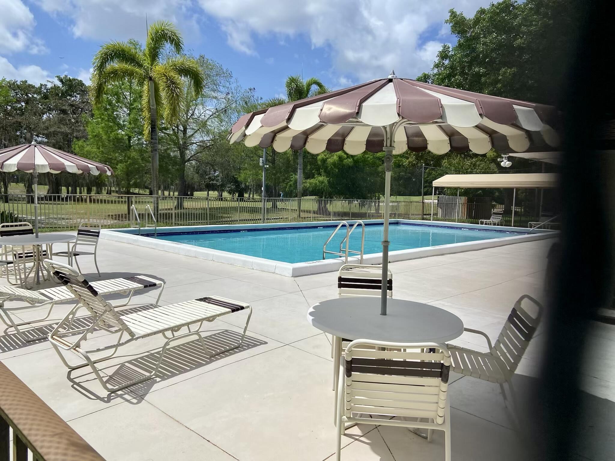 8050 West McNab Road, Unit 320 Tamarac, FL 33321 - Photo 24 of 24 a view of a backyard with swimming pool and furniture