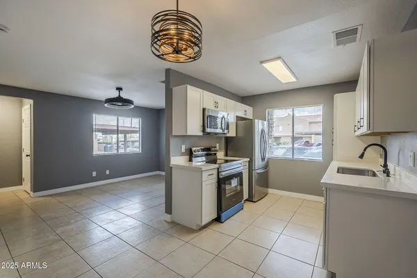 a kitchen with granite countertop a stove a sink a window and stainless steel appliances