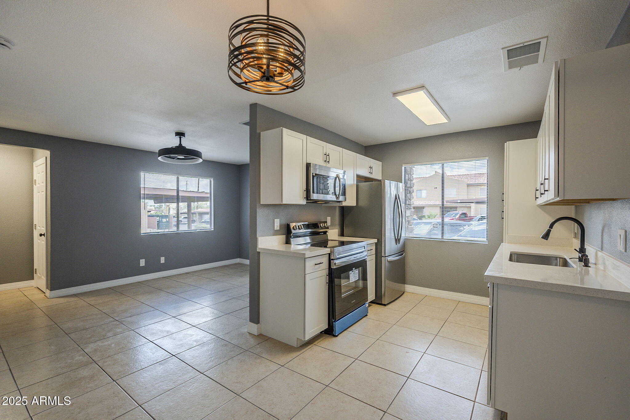 3511 East Baseline Road, Unit 1033 Phoenix, AZ 85042 - Photo 11 of 27 a kitchen with granite countertop a stove a sink a window and stainless steel appliances