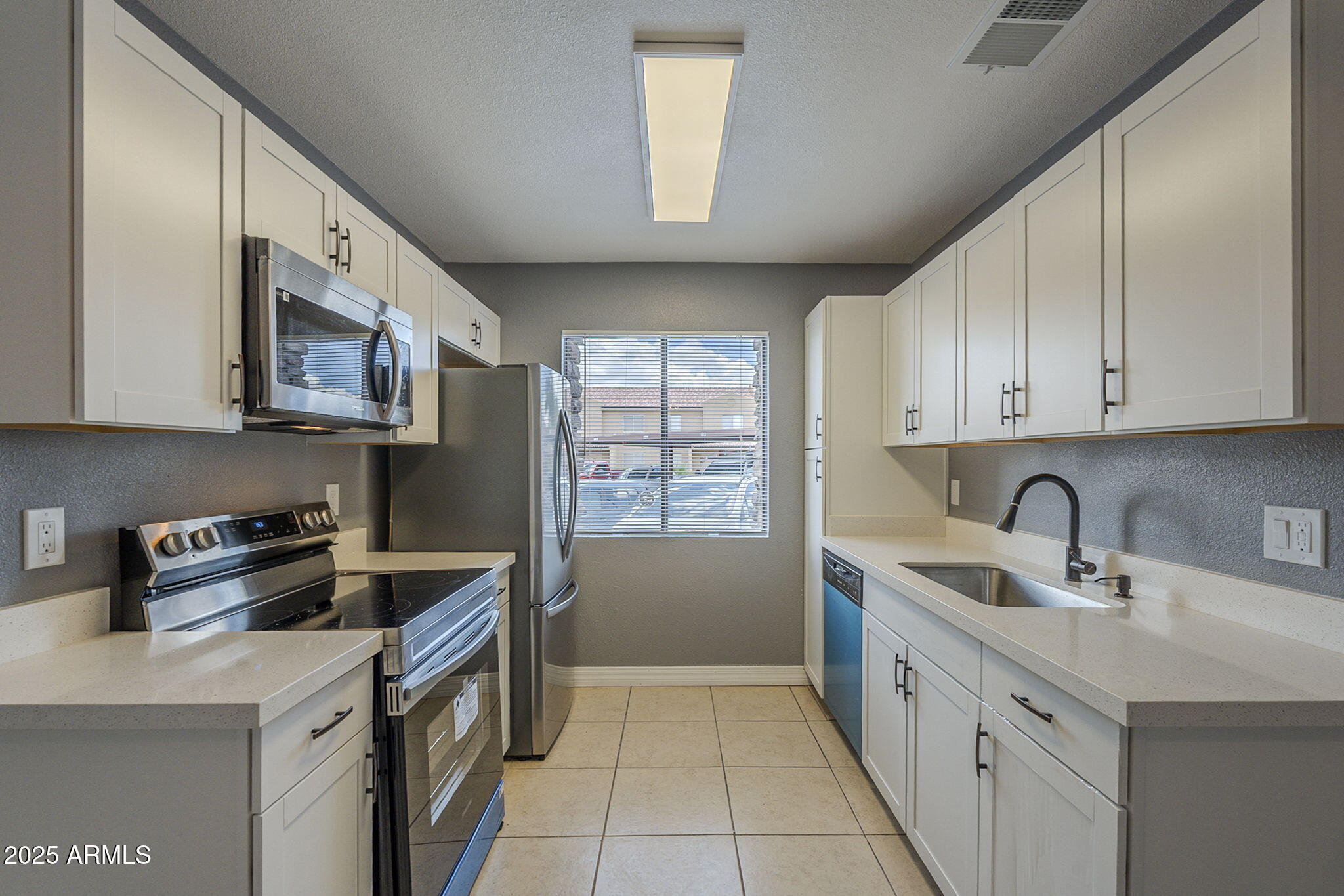 3511 East Baseline Road, Unit 1033 Phoenix, AZ 85042 - Photo 13 of 27 a kitchen with stainless steel appliances a sink stove and cabinets