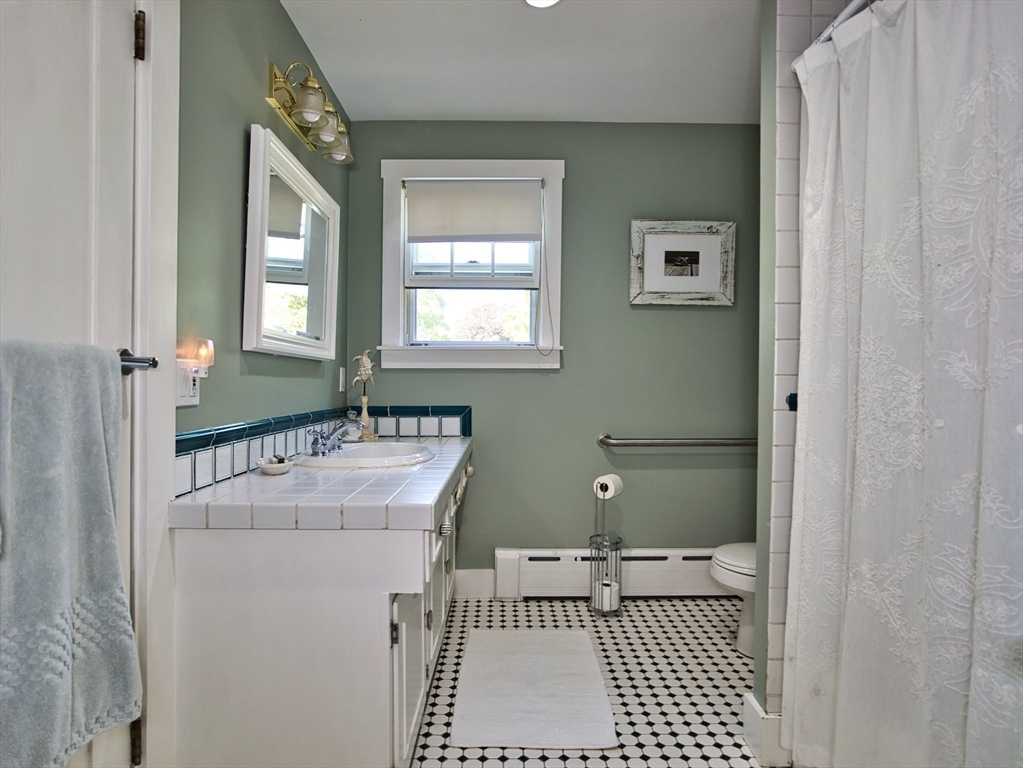 56 Maple Avenue Little Compton, RI 02837 - Photo 12 of 33 a bathroom with a sink a toilet and mirror